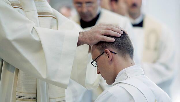 Ein junger Geistlicher wird zum Priester geweiht.