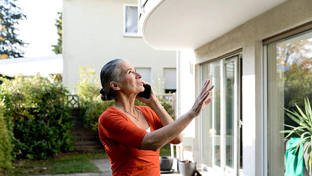 Senior woman talking on mobile phone in front of house model released, Symbolfoto property released, FLLF00825