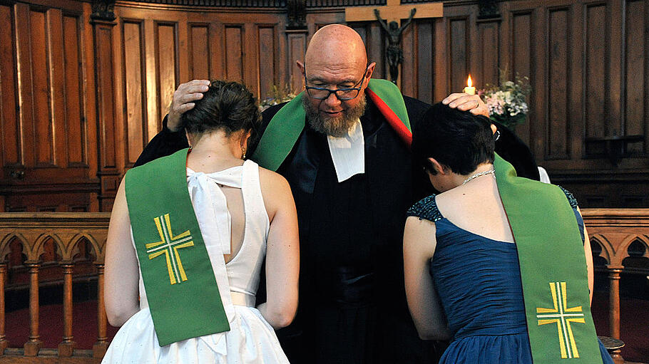 Ein protestantischer Pastor segnet zwei Bräute
