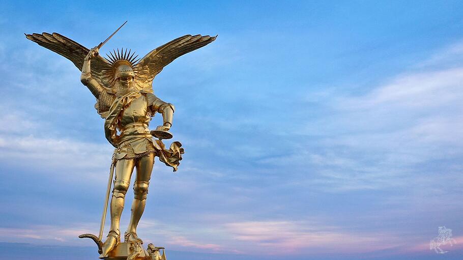 Sonnenaufgang hinter der goldenen Statue des Erzengels Michael