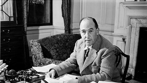 C. S. Lewis im Tweed-Anzug an seinem Schreibtisch.