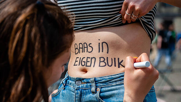 May 7, 2022, Amsterdam, Netherlands: A woman is seen writing on the belly of a colleague the text Boss of my own belly i