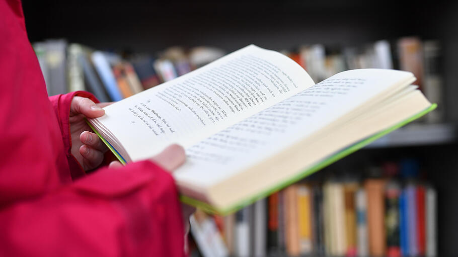 Eine Frau hält ein Buch in den Händen