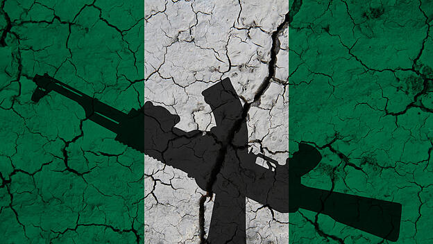 Schatten einer Waffe vor einer rissigen Nigeria-Flagge