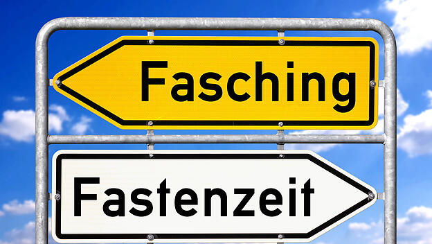 Germany - March 6, 2025: FOTOMONTAGE, A signpost shows two opposite directions with the terms FASCHING and FASTENZEIT **