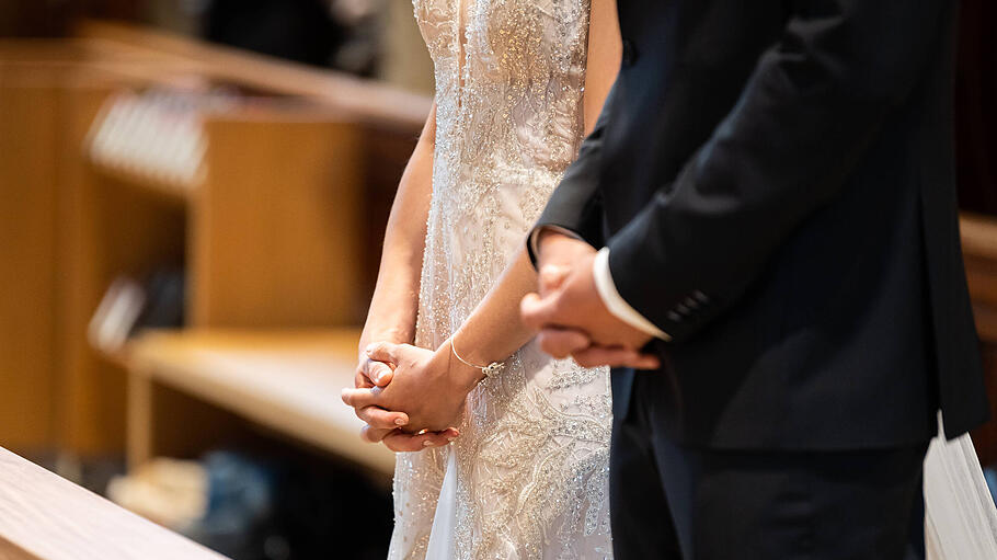Ein Brautpaar faltet während ihrer Trauung in einer katholischen Kirche die Hände. Rottweil Baden-Württemberg Deutschla
