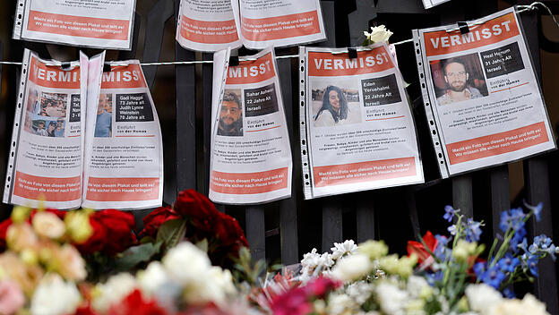 Eine Gedenkstätte mit Blumen und Steckbriefen vermisster Personen nach dem Hamas-Terror an Kölner Synagoge