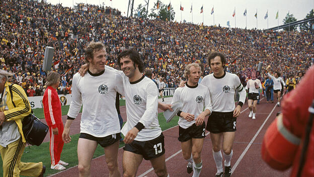 Gerd Müller, Berti Vogts und Franz Beckenbauer laufen nach dem gewonnenen WM-Finale von 1974 eine Ehrenrunde.