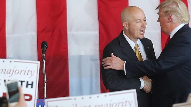 Donald Trump is greeted by Nebraska Republican governor  at campaign rally in Omaha, Nebraska