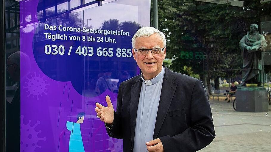Erzbischof Heiner Koch präsentiert das Werbeplakat für die Corona-Seelsorge des Erzbistums