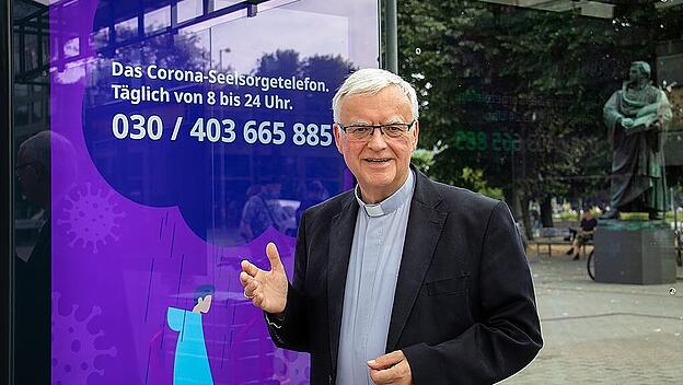 Erzbischof Heiner Koch präsentiert das Werbeplakat für die Corona-Seelsorge des Erzbistums