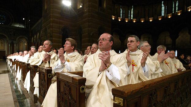 Priester klatschen während eines Gottesdienstes anlässlich der Amtseinführung von Erzbischof Raymond Burke