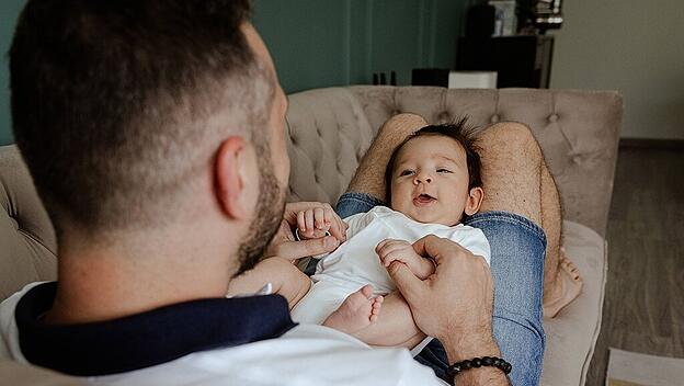 Father playing with smiling baby on couch at home Shanghai, Shanghai, China CR_ITUP231208-1288450-01 ,model released, Sy