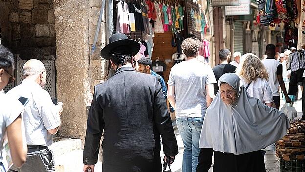 May 18, 2023, Jerusalem, Israel: Palestinian woman walks past an ultra-orthodox Jewish man in the old city of Jerusalem
