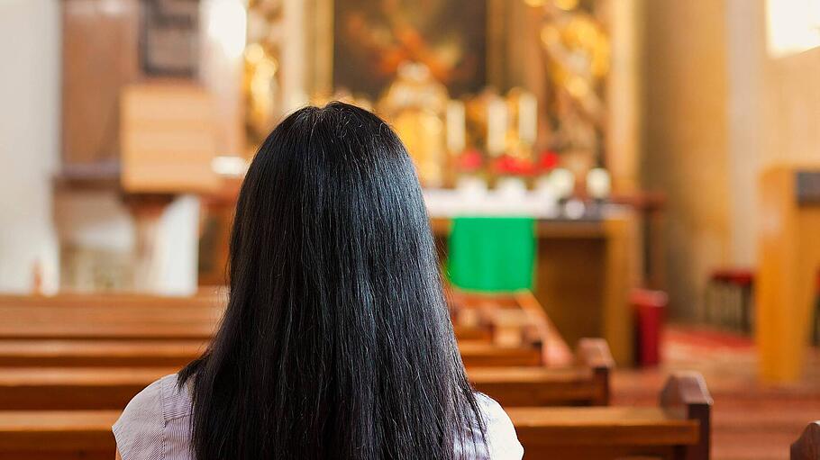 Junge Frau betet in einer Kirche