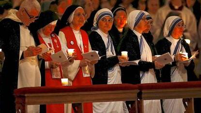 Nuns hold candles as Pope Francis arrives to celebrate a mass in Saint Peter's basilica at the Vatican