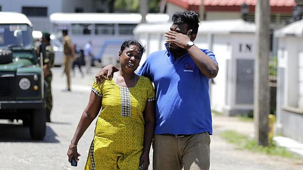 Sri-lankisches Paar verläßt trauernd eine Leichenhalle