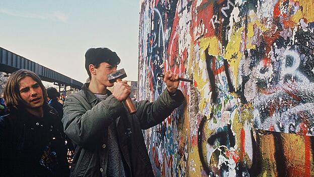 „Mauerspechte“: Nach dem 9. November 1989 wollen immer mehr Menschen selbst ein Stück Mauer heraushauen