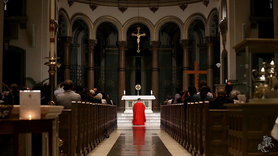 Priester kniet vor dem Altar