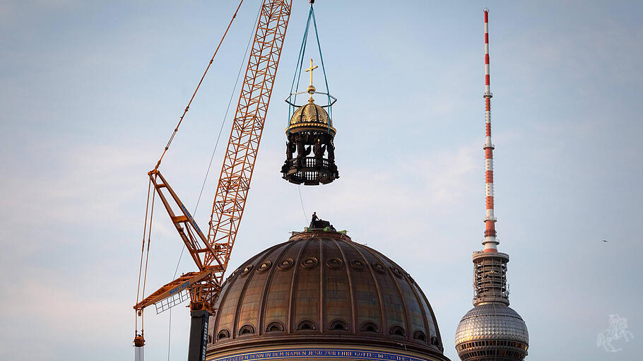 Der Kuppel des Humboldt-Forums in Berlin wird das Kreuz aufgesetzt.