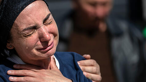 Eine Frau weint während der Beerdigung ihres Sohnes, der während Putins Angriffskrieg gegen die Ukraine  getötet wurde