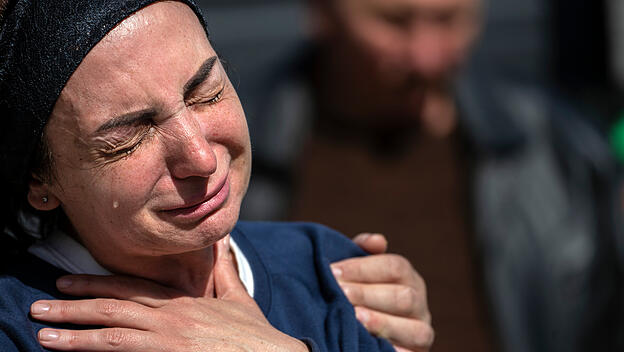 Eine Frau weint während der Beerdigung ihres Sohnes, der während Putins Angriffskrieg gegen die Ukraine  getötet wurde