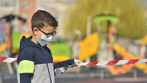 Kind auf abgesperrtem Spielplatz