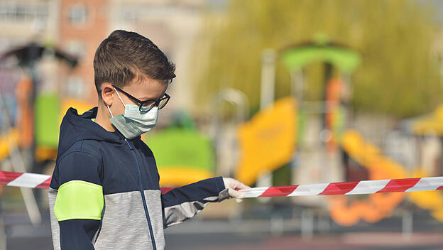 Kind auf abgesperrtem Spielplatz