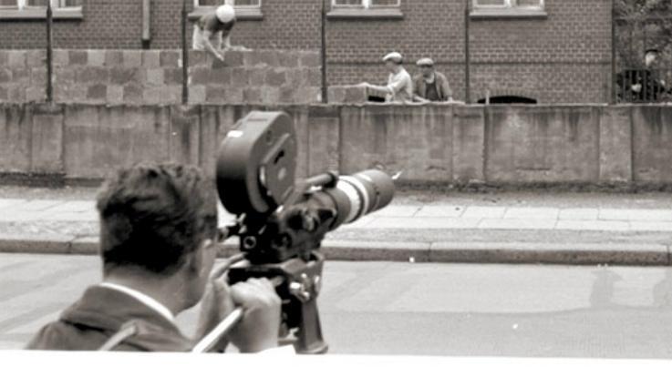 Ein Kameramann filmt im Westen Bauarbeiter aus der DDR