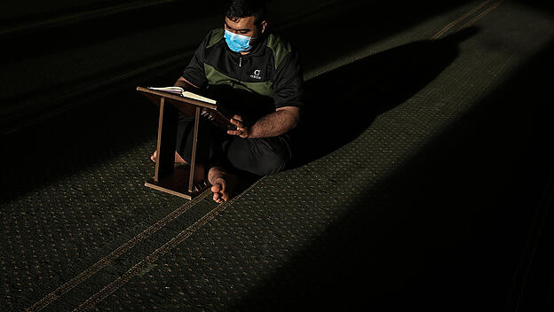 Mann liest den Koran während des Fastenmonats Ramadan