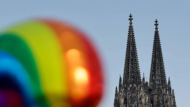 Ein Ballon in Regenbogenfarben neben dem Kölner Dom