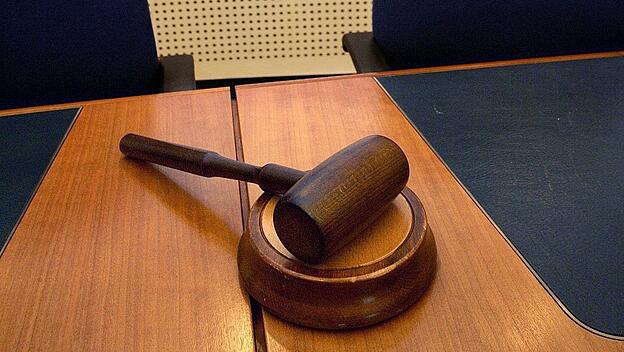 Ein Hammer liegt am Platz des Richters in einem Gerichtssaal