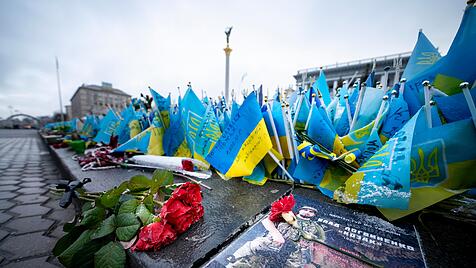 Rosen und ukrainische Fahnen für gefallene Soldaten und zivile Opfer der russischen Invasion