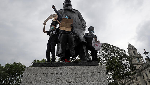 Demonstranten stehen auf der Statue des ehemaligen britischen Premierministers Winston Churchill.