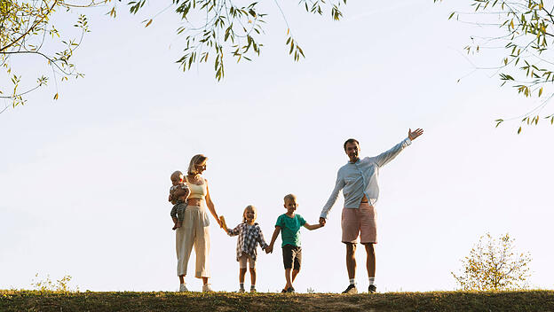 Happy family holding hands and standing in park model released, Symbolfoto, NDEF01274