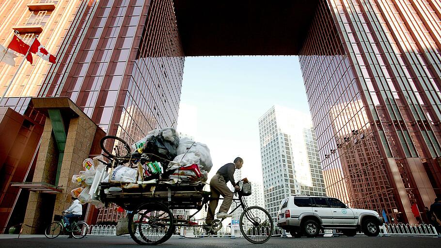 Müllsammler vor modernen Wolkenkratzern in Peking