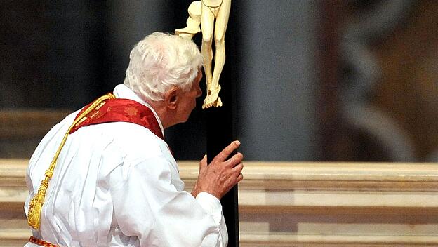 Der emeritierte Papst Benedikt XVI. k&uuml;sst das Kreuz bei der Karfreitagsliturgie 2012 im Petersdom