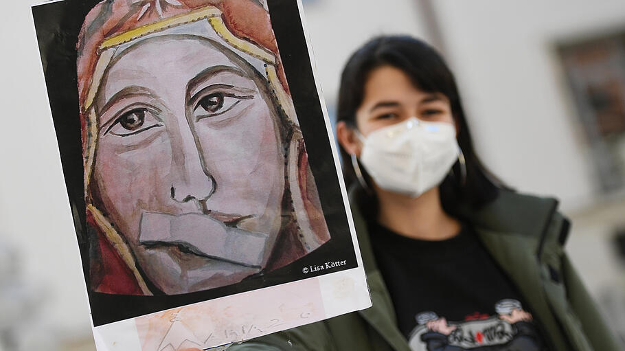 Aktivistin der katholischen Reforminitiative «Maria 2.0» hält ein Plakat mit Maria mit einem Pflaster auf dem Mund in die Höhe