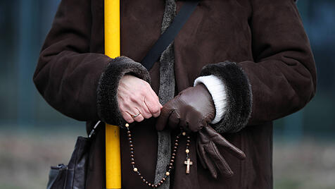 Frau betet Rosenkranz in der &Ouml;ffentlichkeit