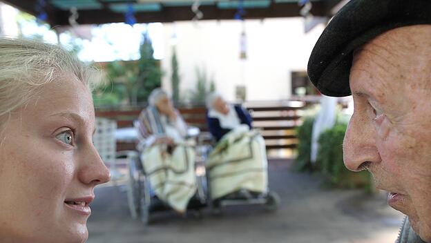 Eine freiwillige Helferin im Gespräch mit einem Bewohner des Heims Beit Elieser in Ma'alot